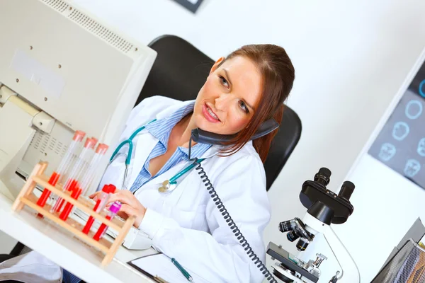 Concerned female medical doctor talking on phone and looking in — Stock Photo, Image