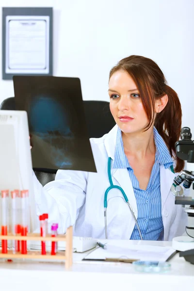 Doktor kvinna sitter vid office bord och analysera patienter roen — Stockfoto
