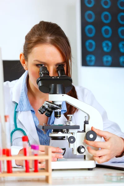 Médica feminina usando microscópio em laboratório médico — Fotografia de Stock