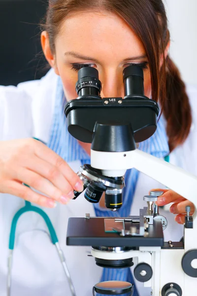 Mujer investigadora usando microscopio en laboratorio médico. De cerca. — Foto de Stock