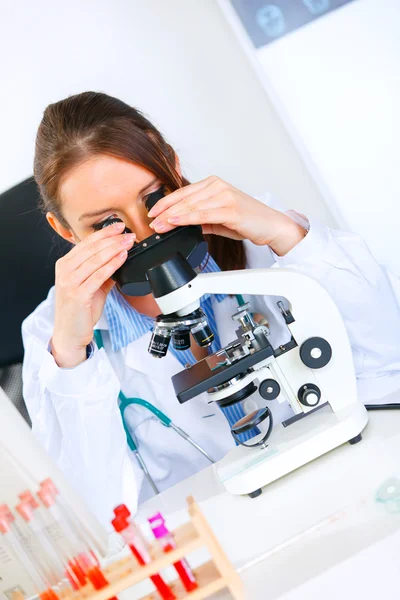 Pesquisadora mulher usando microscópio em laboratório médico. Fechar — Fotografia de Stock