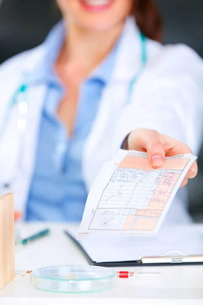 Docteur femme assise à la table du bureau et donnant une prescription médicale. Fermer — Photo