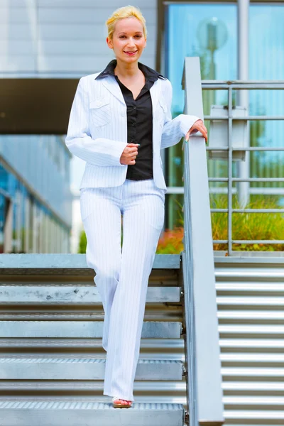 Mujer de negocios sonriente bajando escaleras — Foto de Stock