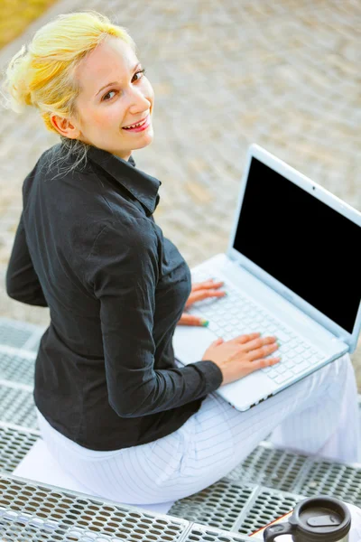 Щаслива сучасна бізнес-леді сидить на сходах в офісному будинку — стокове фото