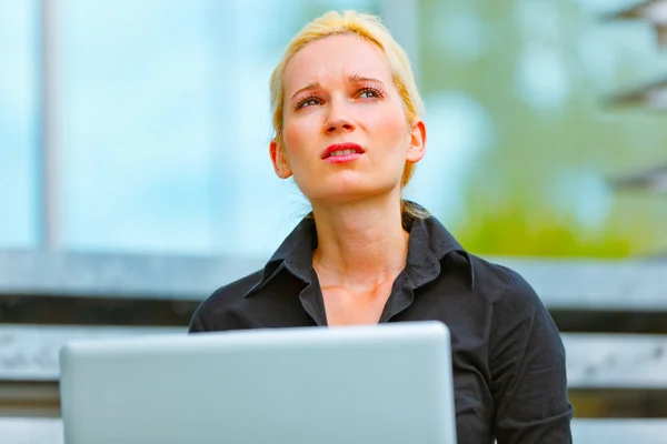Pensive business woman sitting on stairs at office building — Stock Photo, Image