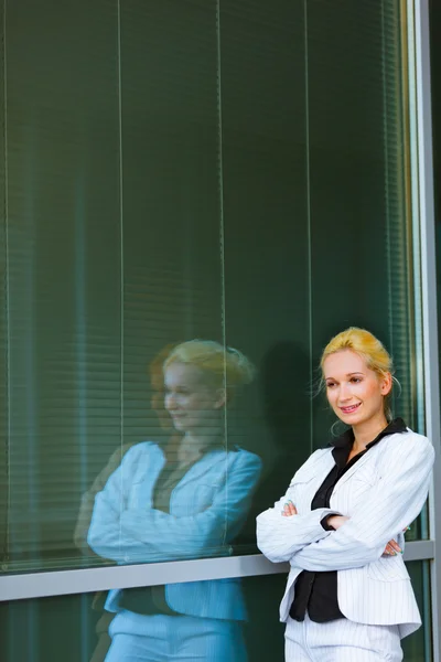 Zamyślony biznes kobiety stojącej w pobliżu budynek biurowy — Zdjęcie stockowe