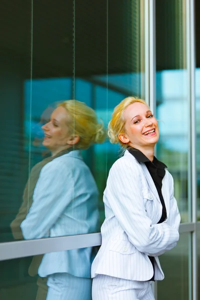 Śmiejąc się biznes kobieta ze skrzyżowanymi rękami na piersi w budynku biurowym — Zdjęcie stockowe
