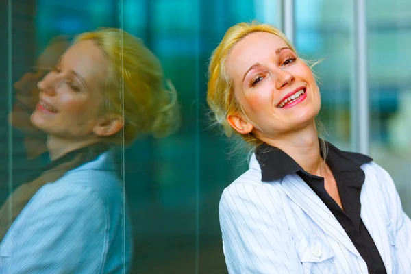 Smějící se obchodní žena stojící na kancelářská budova — Stock fotografie