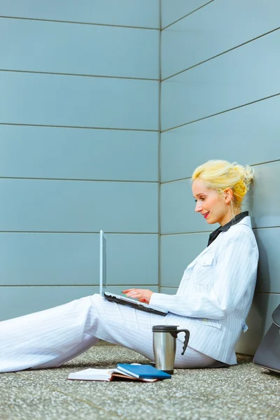 Nadenkend zakenvrouw zittend op de vloer op kantoorgebouw — Stockfoto