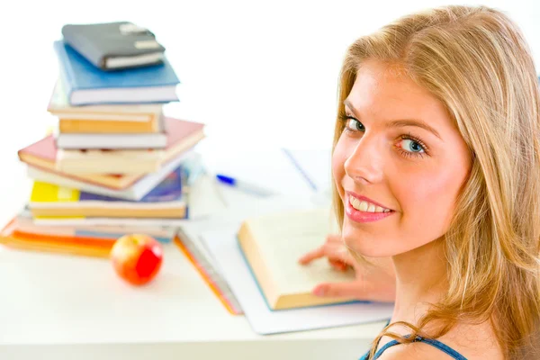 Smiling teengirl sitting at table with books — Stock Photo, Image