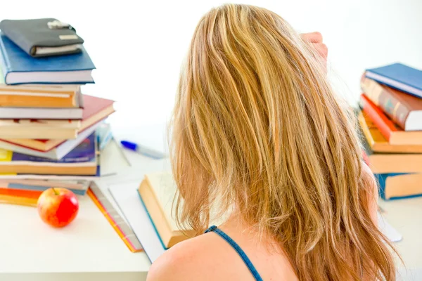 Studeren tiener meisje aan tafel zit met stapels boeken — Stockfoto