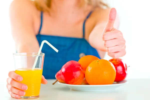 Girl sitting at table and giving orange juice. Close up — Stock Photo, Image