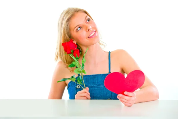 Chica soñadora sentada en la mesa con rosa y corazón de San Valentín —  Fotos de Stock