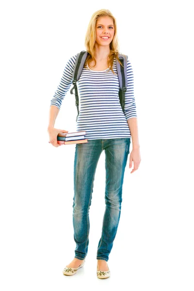 Full length portrait of smiling teengirl with schoolbag holding books in ha — Stock Photo, Image