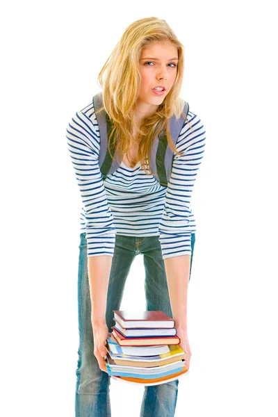 Chockad teen flicka håller tunga högen av böcker i händer — Stockfoto