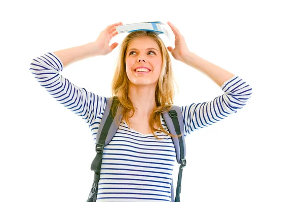 Vrolijke tiener meisje balancing boek bovenop haar hoofd — Stockfoto