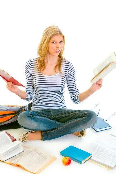 Sorprendida chica adolescente sentada en el suelo con libros y preparándose para los exámenes — Foto de Stock