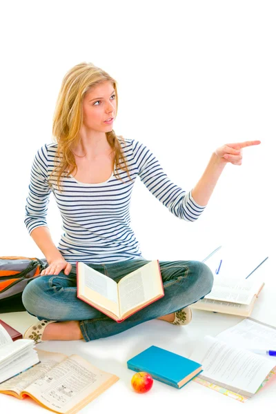 Cheerful teen girl sitting on floor among schoolbooks and pointi — Stock Photo, Image