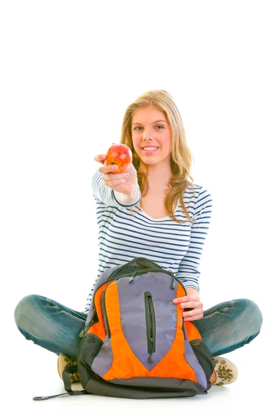 Adolescente alegre sentado no chão com saco escolar e dando aplicativo — Fotografia de Stock