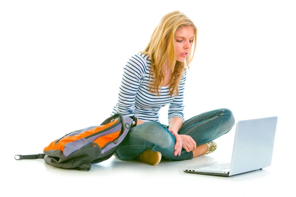 Interessato bella ragazza seduta sul pavimento con zaino e alla ricerca — Foto Stock