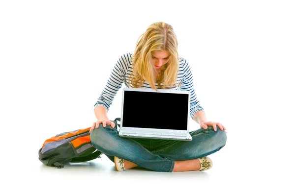Katta oturan ve dizüstü bilgisayarlar üzerinde boş bir ekran arayan genç kız — Stok fotoğraf