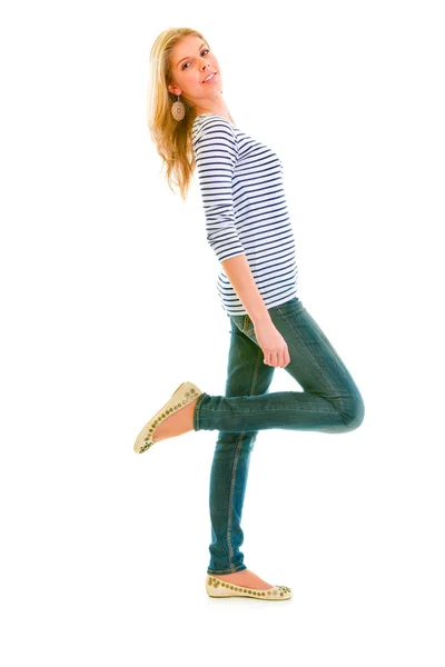Celovečerní portrét smějící se krásné dospívající dívky, které stojí na jedné noze — Stock fotografie