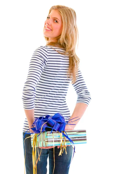 Lächelndes Teenie-Mädchen versteckt Geschenk hinter dem Rücken — Stockfoto