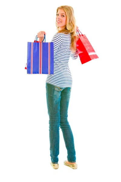Lachende tiener meisje met boodschappentassen Terugkijkend — Stockfoto