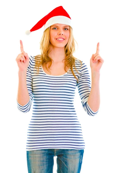 Söt tonåring tjej i santa hatt pekar uppåt — Stockfoto