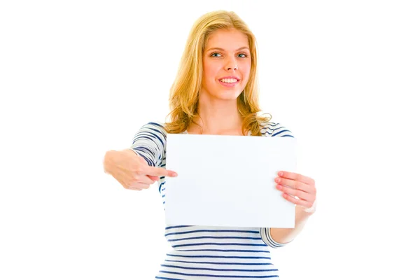 Pretty teen girl pointing on blank paper sheet — Stock Photo, Image