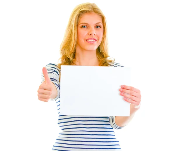 Sorridente giovanissima ragazza holding blank paper e mostrando pollice su — Foto Stock