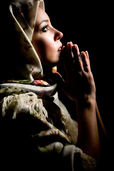 Portrait of beautiful praying girl with old russian shawl on head. Retouche Stock Image