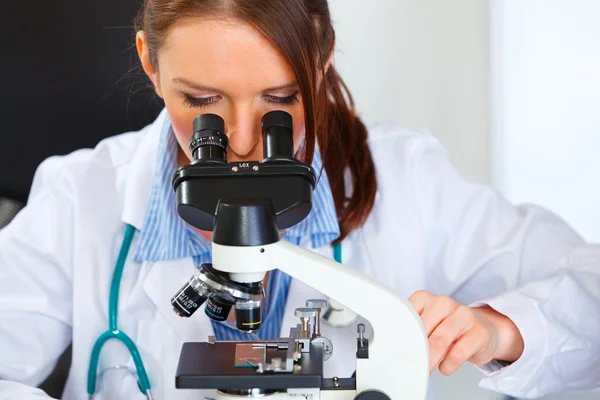 Closeup on doctor woman working with microscope in laboratory Royalty Free Stock Photos