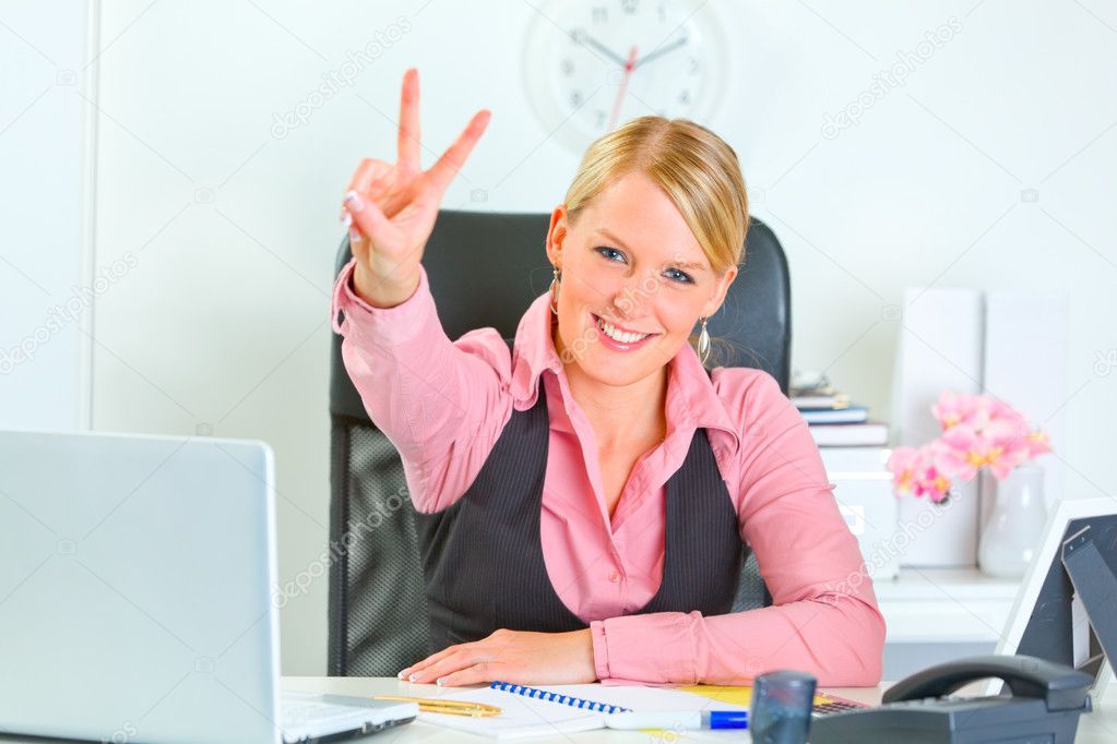 Smiling business woman sitting at office desk
