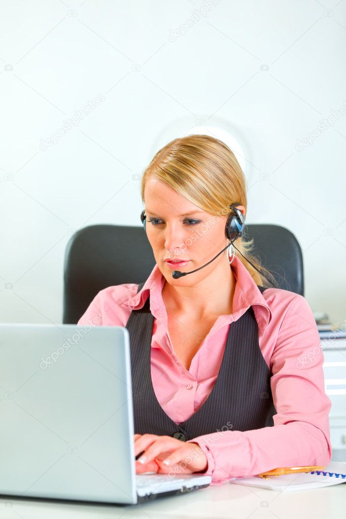 Modern business woman with headset working on laptop