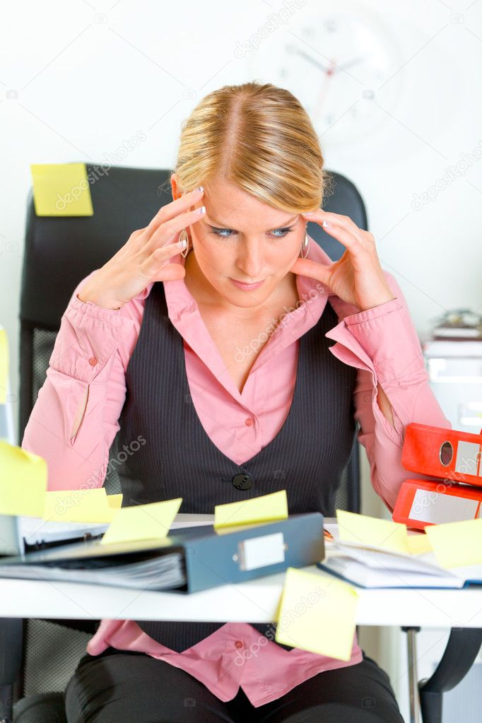 Tired business woman sitting at workplace overwhelmed with sticky reminder