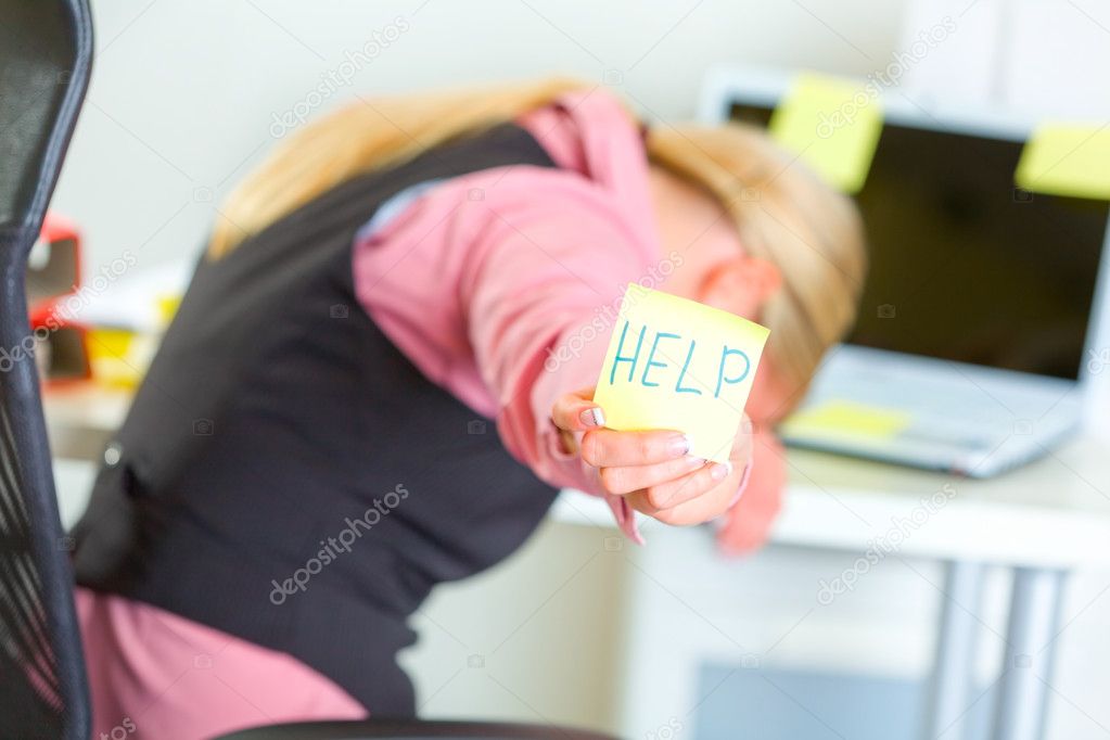 Tired business woman showing sticky note with help word
