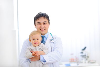 Pediatrik doktor gülümseyen güzel bebek tutan portresi