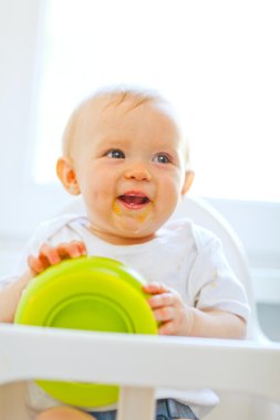plaka ile oynayan Bebek Koltuğu lekeli neşeli bebek kız yemek