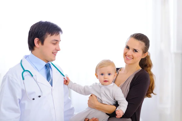 Bebê bonito em mães mão tocando estetoscópio de médico pediátrico — Fotografia de Stock