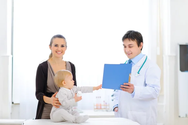 Interessiertes Baby reicht Patientenkarte — Stockfoto