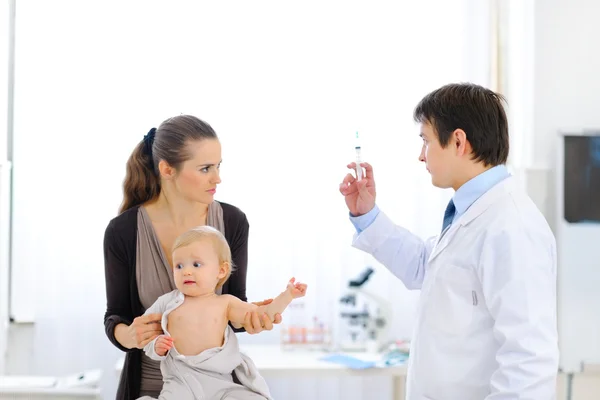 Pediatrician doctor with syringe, tense mother and unhappy baby — Stock Photo, Image