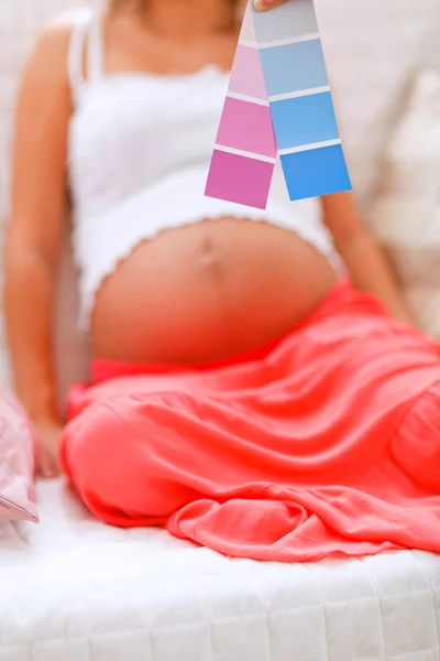 Färg prover och gravid kvinna i bakgrunden — Stockfoto