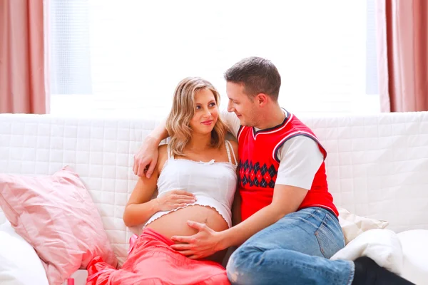 Jovem marido feliz segurando sua barriga de mulheres grávidas — Fotografia de Stock