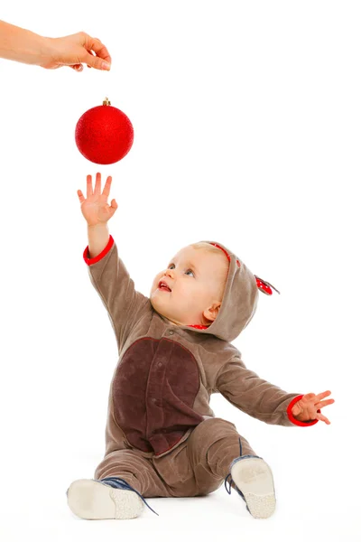 Alegre bebé jugando estirando la mano a la bola de Navidad — Foto de Stock