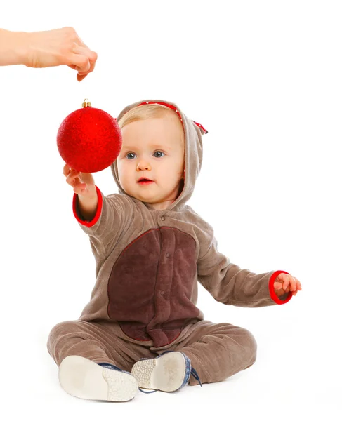 Прекрасна дитина тягнеться до різдвяного м'яча — стокове фото