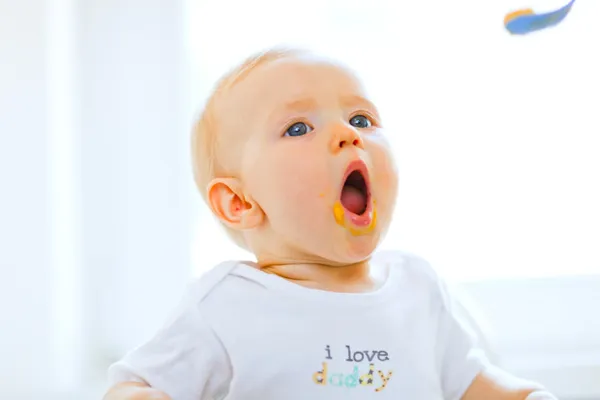 Comer manchado adorável bebê boca aberta para colher — Fotografia de Stock