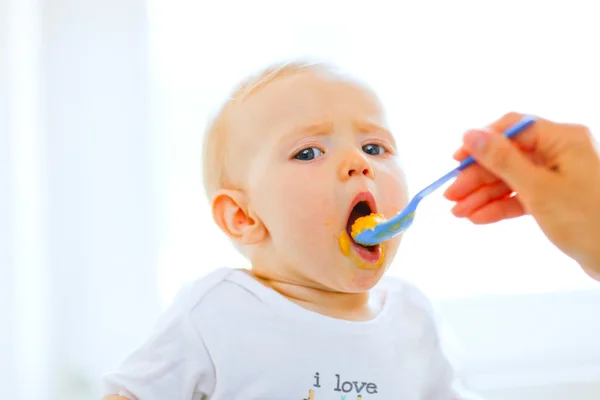 Comer manchado bonito bebê boca aberta para colher — Fotografia de Stock