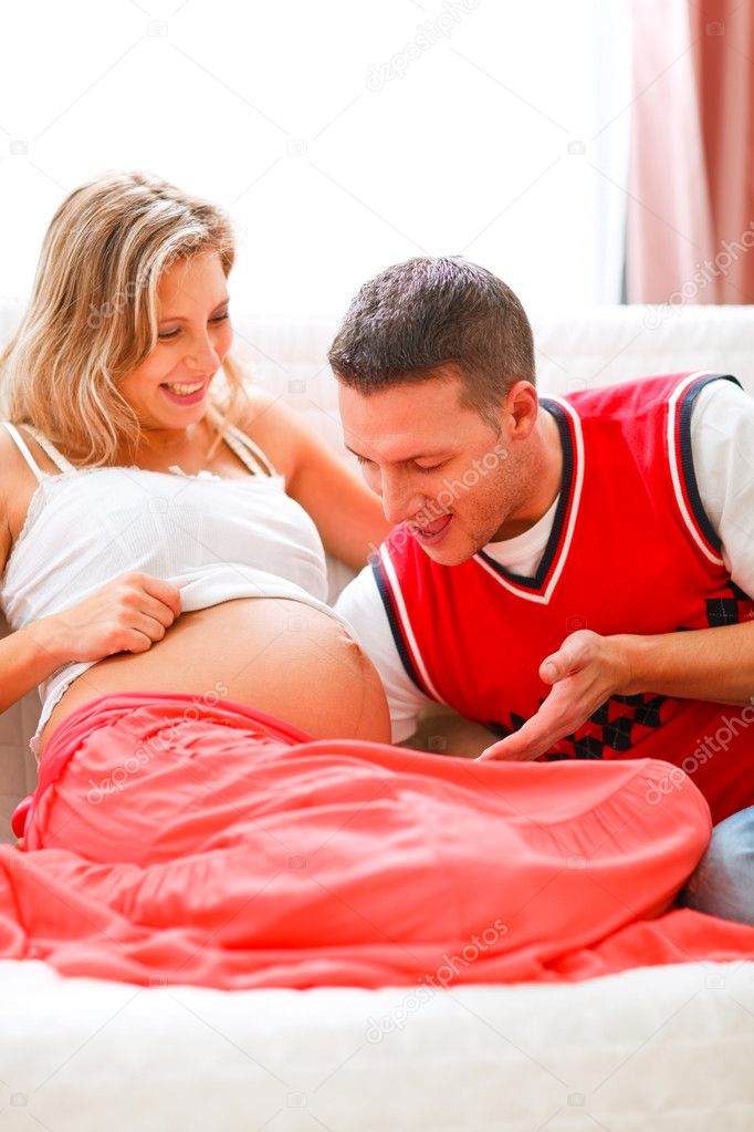 Young father speaking with his pregnant wifes tummy