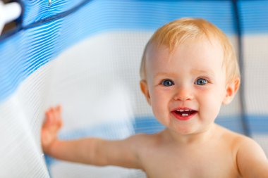 Portrait of happy baby in playpen clipart